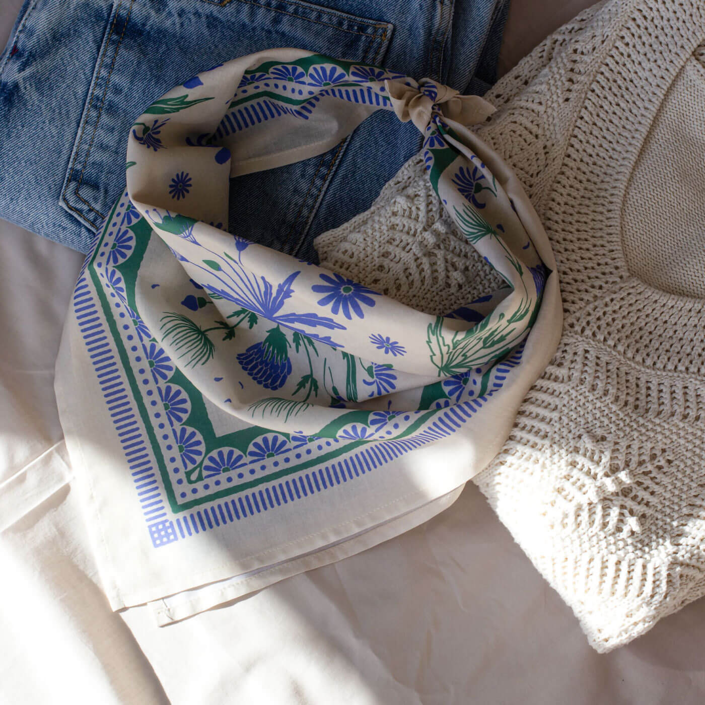 Decorative bandana with blue and green patterns on a beige background