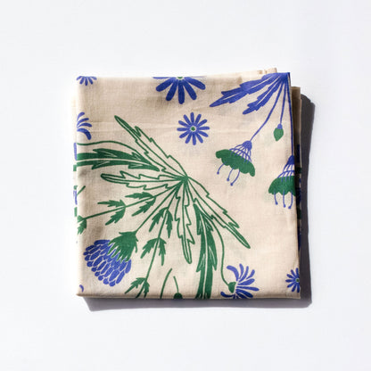 Folded bandana with blue and green floral patterns on a white background