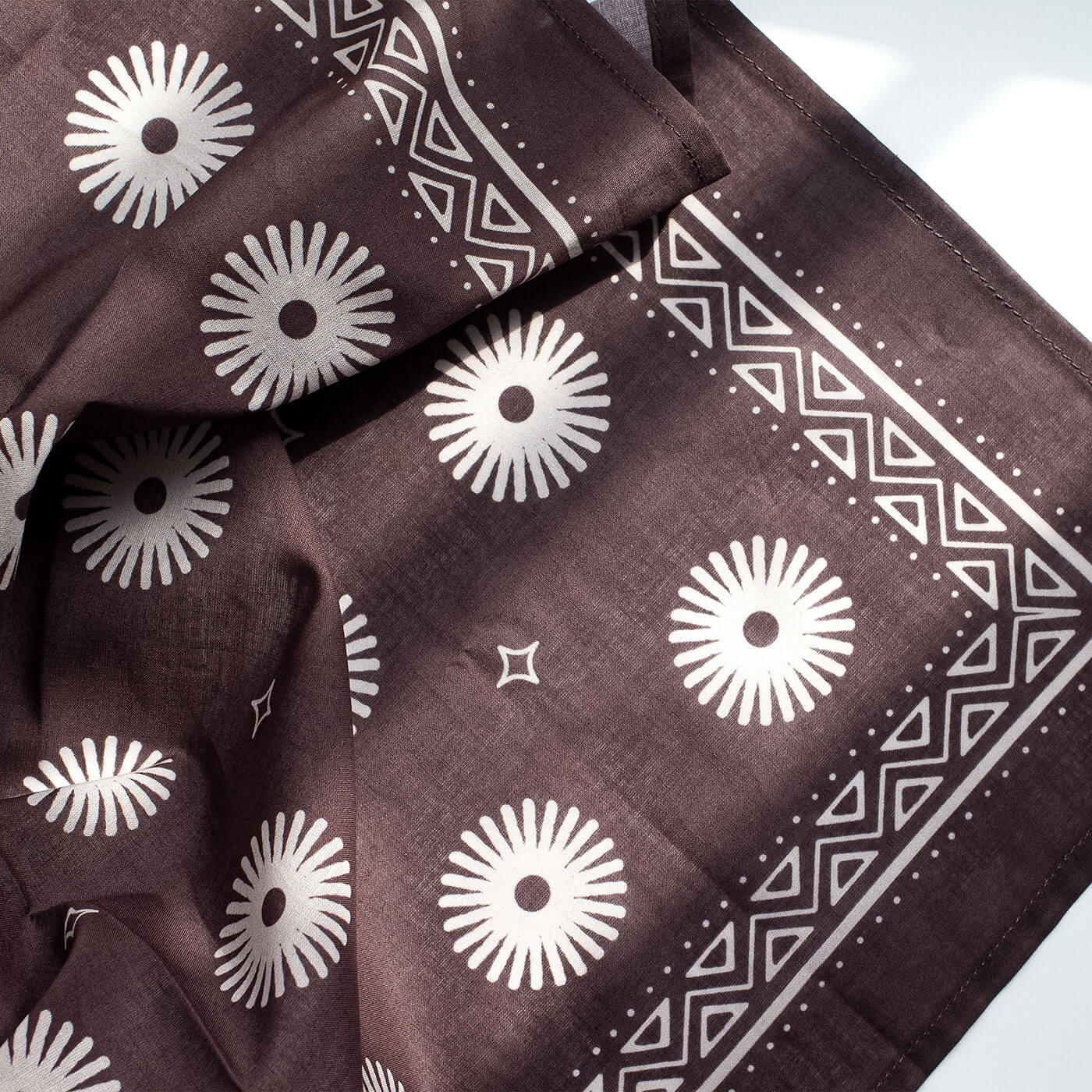 Brown bandana with white geometric patterns on a white background