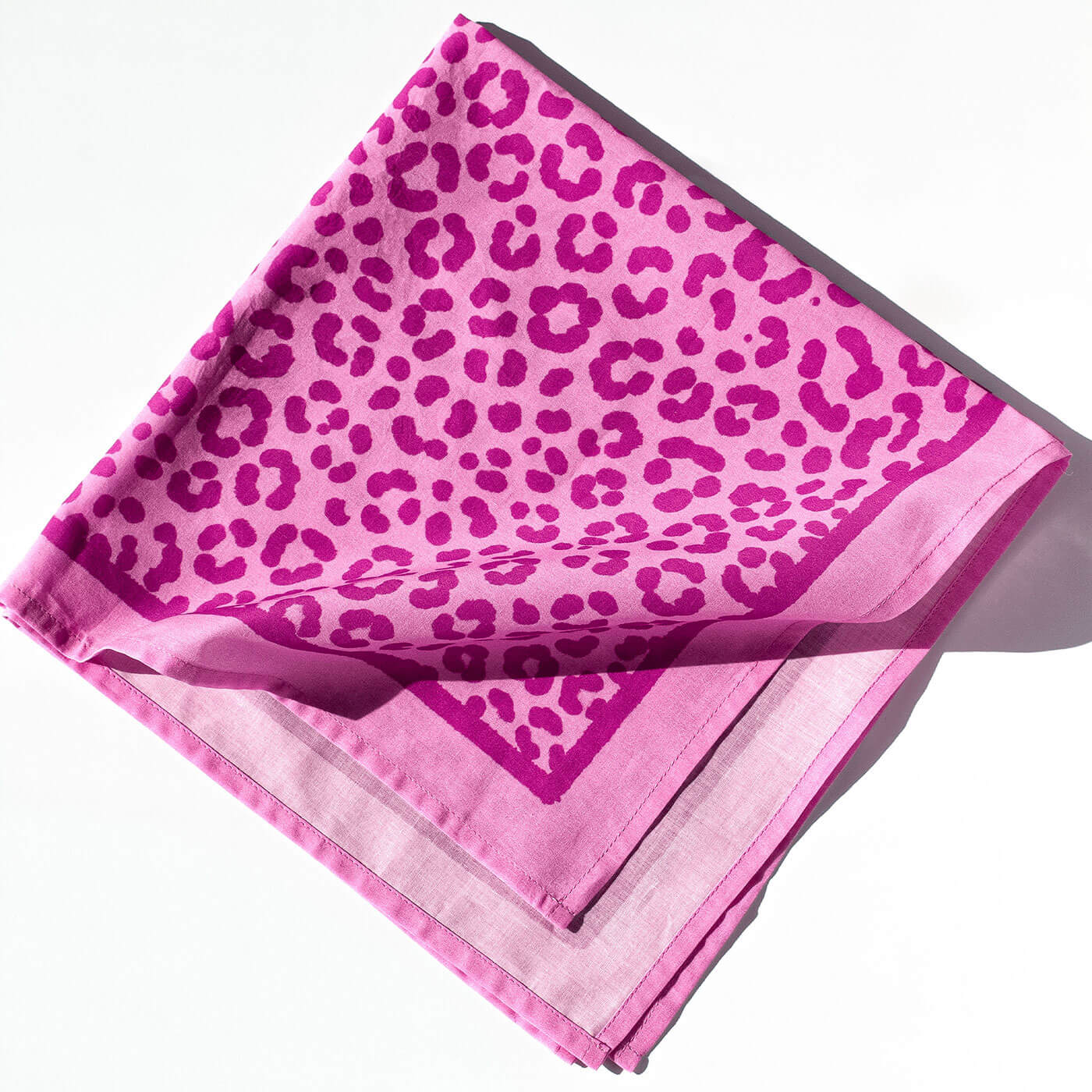 Pink scarf with leopard print pattern on a white background