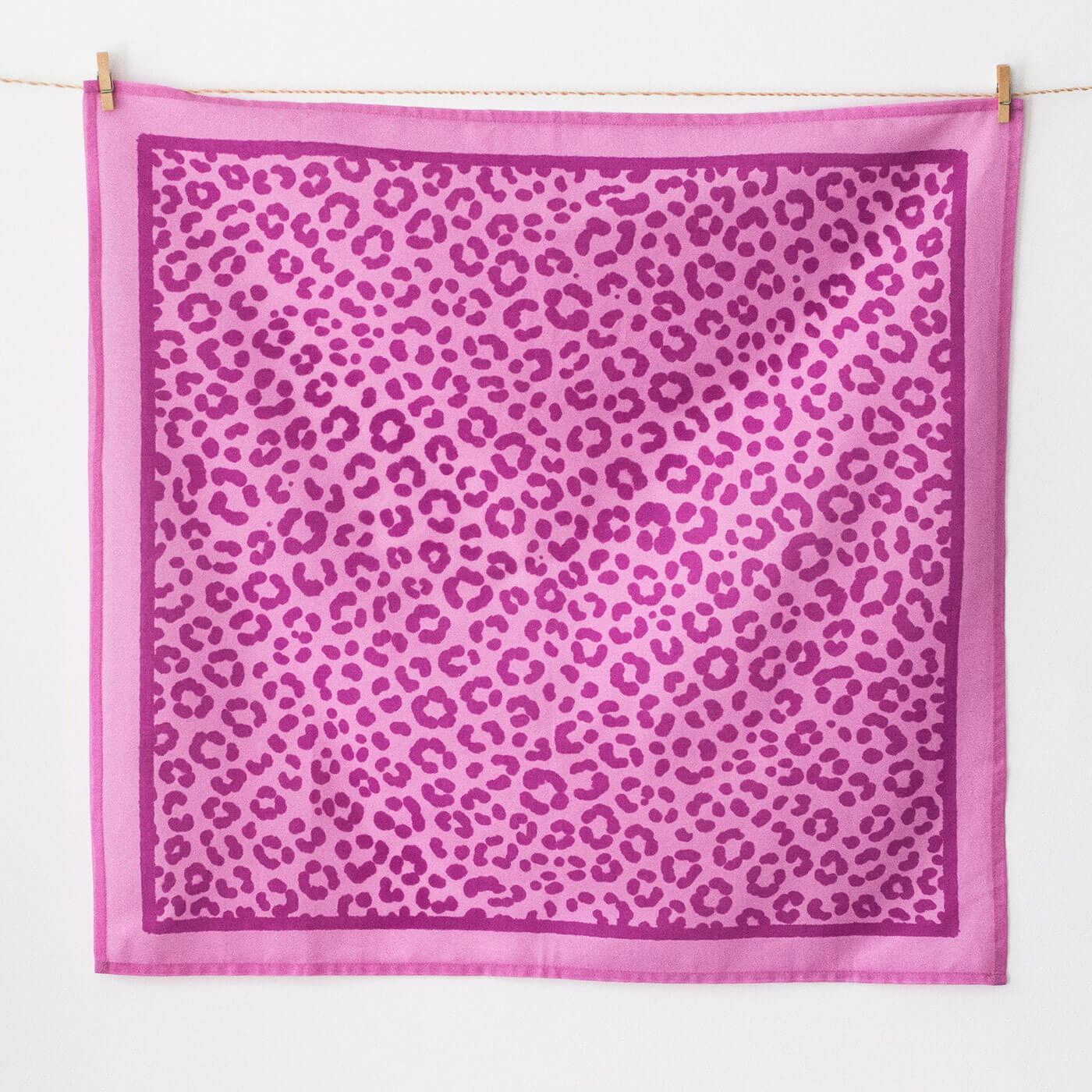 Pink square scarf with leopard print pattern on a white background