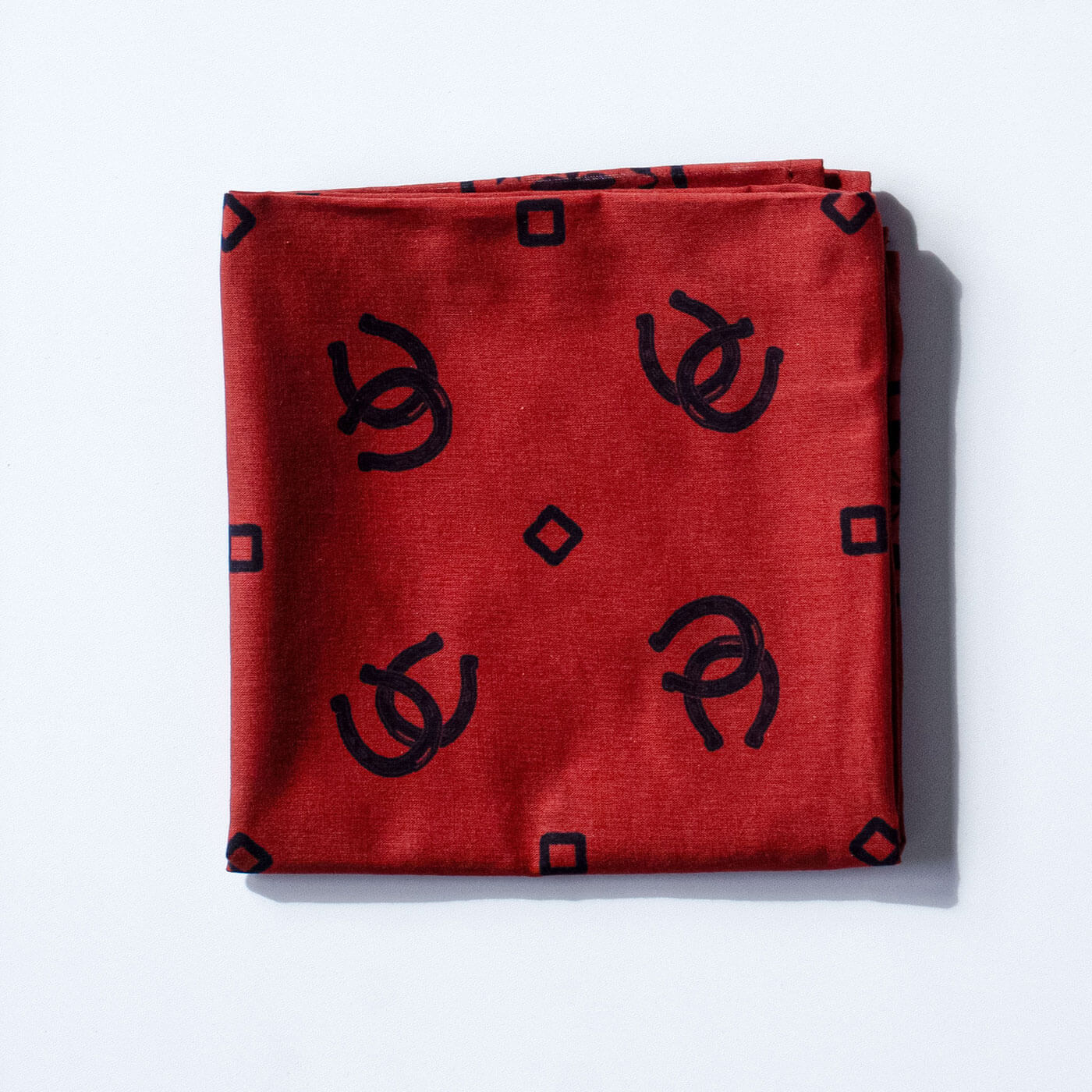 Red bandana with black geometric patterns on a white background