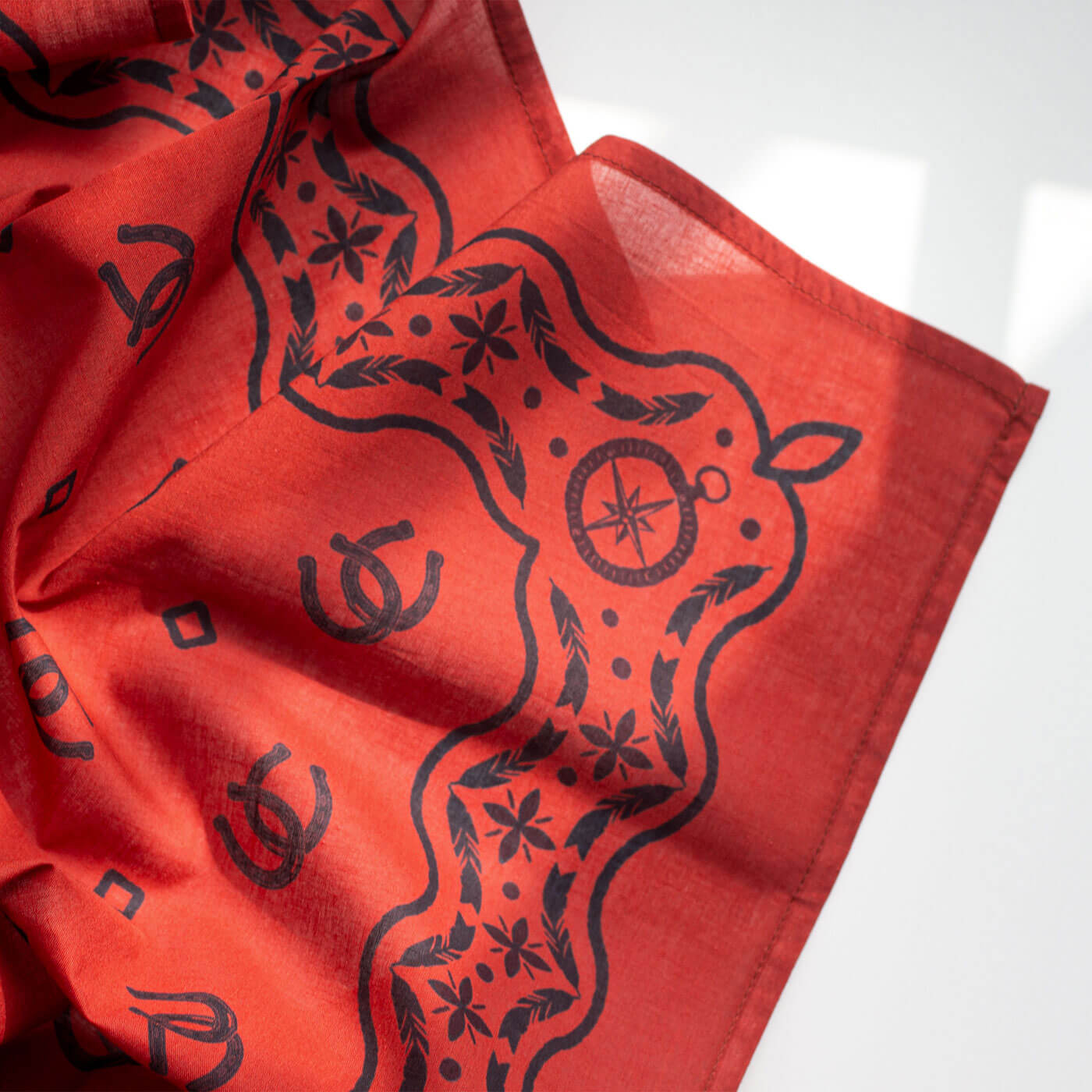 Red bandana with black deer design on a white background