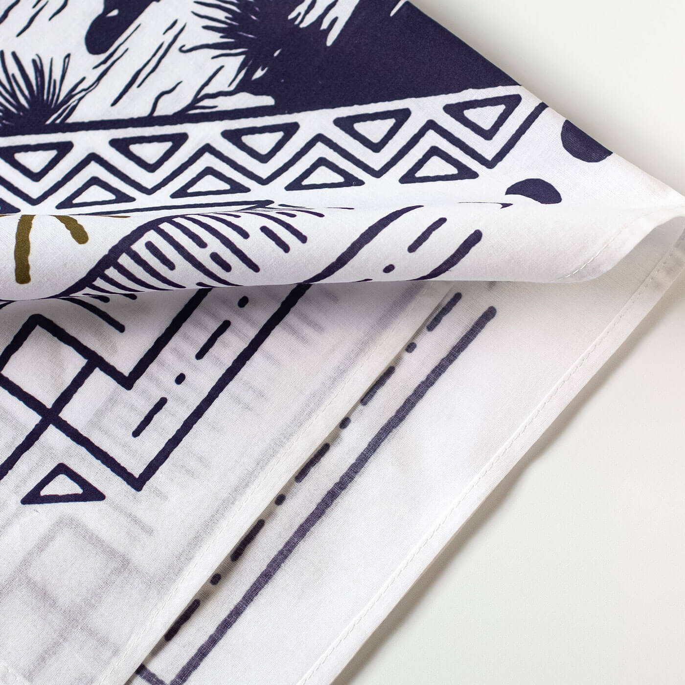 Close-up of patterned bandana with geometric and abstract designs on a white background